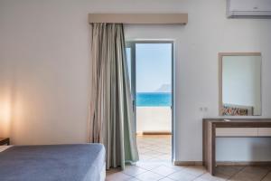 a bedroom with a bed and a view of the ocean at Wink Bnb Paraliaki in Kissamos
