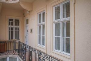 einen Balkon eines Hauses mit weißen Fenstern in der Unterkunft Boutique Soho Apartment in Budapest