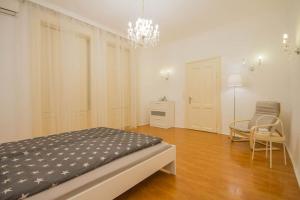 ein Schlafzimmer mit einem Bett, einem Stuhl und einem Kronleuchter in der Unterkunft Boutique Soho Apartment in Budapest