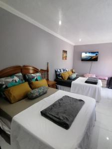 een hotelkamer met twee bedden en een bank bij Mila Lodge 1 in Kaapstad