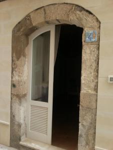 シラクーサにあるCasa del Vicoloの白い扉のアーチ道