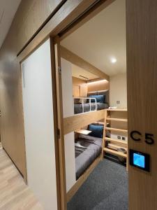 um pequeno quarto com um beliche num quarto em sleep 'n fly Sleep Lounge & Showers, NORTH Node - TRANSIT ONLY em Doha
