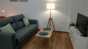 een woonkamer met een blauwe bank en een tafel bij Apartamento Camposoto in San Fernando