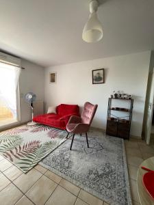 - un salon avec un lit rouge et une chaise dans l'établissement Le Nomade, Parc Montcalm et stationnement privé, à Montpellier