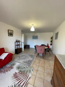 sala de estar con sofá rojo y mesa en Le Nomade, Parc Montcalm et stationnement privé, en Montpellier