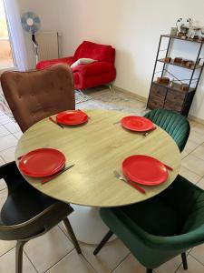 une table en bois avec des plaques et des chaises rouges dans l'établissement Le Nomade, Parc Montcalm et stationnement privé, à Montpellier