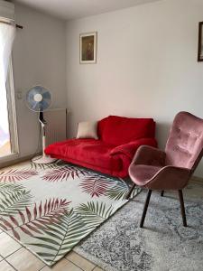 sala de estar con sofá rojo y silla en Le Nomade, Parc Montcalm et stationnement privé, en Montpellier