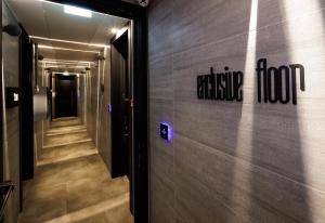 a hallway in a building with a sign on the wall at The Corner Duomo Hotel in Milan