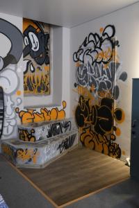 um quarto com uma parede coberta de graffiti em Wanderlust hostel Riverside em Almaty