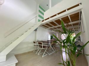 a room with a staircase with a table and chairs at Beach house in Baan Tai