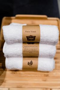 stos ręczników na drewnianej tacy w obiekcie sleep 'n fly Sleep Lounge & Showers, NORTH Node - TRANSIT ONLY w mieście Doha