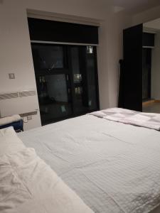 uma grande cama branca num quarto com uma janela em Jadwin Beautiful Room Share toilet 2 people em Londres