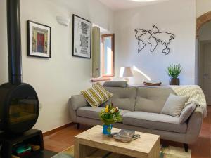 sala de estar con sofá y TV en Grove Cottage: Immersed in nature & close to town, en Città della Pieve
