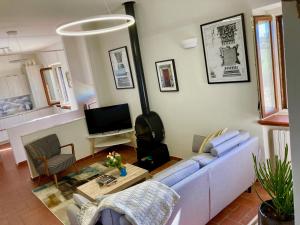 sala de estar con sofá azul y TV en Grove Cottage: Immersed in nature & close to town, en Città della Pieve