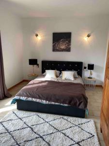 sypialnia z dużym łóżkiem z 2 lampami w obiekcie Maison 6 personnes avec piscine terrain arboré clôturé w mieście Vallabrix