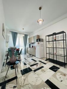 een keuken met een tafel en stoelen en een koelkast bij Family apartment near Palas Mall in Iaşi