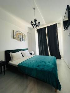 una camera con letto verde e lampadario a braccio di Family apartment near Palas Mall a Iaşi