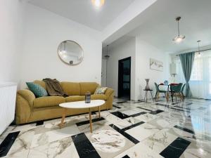 een woonkamer met een bank en een tafel bij Family apartment near Palas Mall in Iaşi