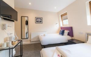a small room with two beds and a mirror at Saba Rooms And Apartments in London