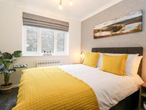 Un dormitorio con una cama grande con almohadas amarillas. en Bluebell Hill, en Windermere