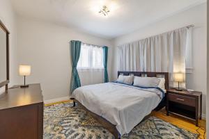 a bedroom with a bed and a dresser and a window at 2 Bedroom Near Trolley Square and Liberty Park! in Salt Lake City