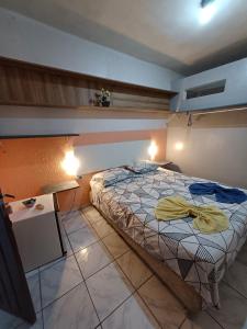 a bedroom with a bed and a table and lights at Pousada Lucrezia in Maceió