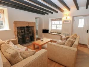 a living room with two couches and a fireplace at Buttercup Cottage in Bakewell
