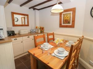 a kitchen and dining room with a wooden table and chairs at Buttercup Cottage in Bakewell