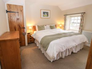 a bedroom with a large bed and a window at Buttercup Cottage in Bakewell