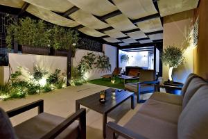 a living room with couches and tables and plants at Art Spa Zeus in Pula