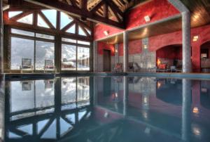 a swimming pool in a building with a mountain view at Hôtel Les Suites du Montana by Les Etincelles in Tignes