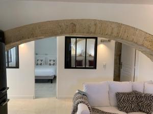 a living room with a white couch and a window at L'Appartement de La Mouline in Pézenas