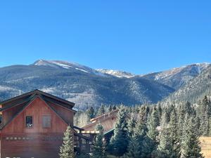 a wooden house with mountains in the background at Mountain Beauty With High Speed Wifi in Red River