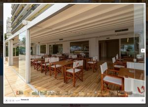 a restaurant with wooden tables and chairs and a dining area at La Dolce Vita Hotel in Menton