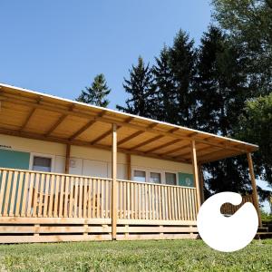 a house with a wooden porch with a letter c at Terme Village - Mobile Homes in Čatež ob Savi