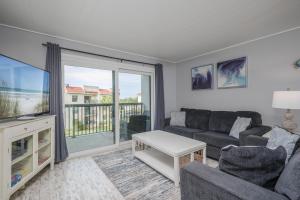 Una sala de estar con un sofá y un televisor. en Ocean Village Club P33, en St. Augustine