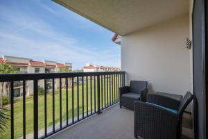 balcón con 2 sillas y vistas a un patio en Ocean Village Club P33, en St. Augustine
