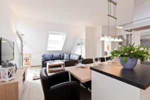 een keuken en een woonkamer met een tafel en stoelen bij Jann 66 in Norderney