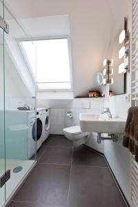 een badkamer met een wastafel en een wasmachine bij Jann 66 in Norderney