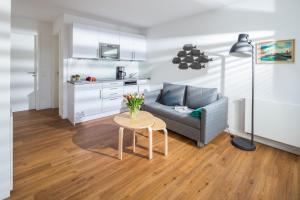 a living room with a couch and a table with flowers at John Silver in Norderney +8 photos