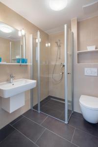 a bathroom with a shower and a sink and a toilet at John Silver in Norderney