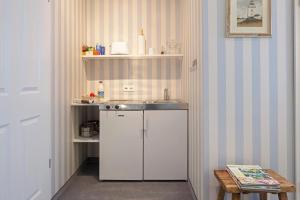 Una cocina con fregadero y refrigerador blanco. en Lenz, en Norderney