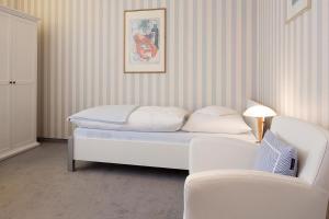 Habitación con cama, sofá y silla en Lenz, en Norderney