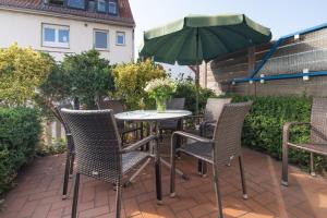 ein Tisch und Stühle mit einem Sonnenschirm auf einer Terrasse in der Unterkunft Haus Friederike in Norderney