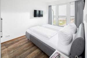 um quarto branco com uma cama e uma janela em Kaiserhof 76 em Norderney