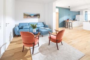 a living room with a couch and a table and chairs at Haus Lola in Norderney