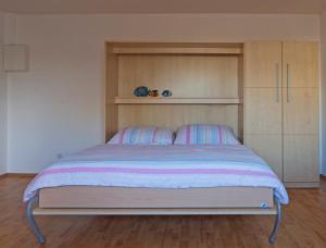 Un dormitorio con una cama grande con armarios de madera. en Meer und mehr, en Norderney