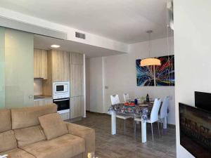 een keuken en een woonkamer met een tafel en een bank bij Apartamento de lujo en primera linea de playa in Benidorm
