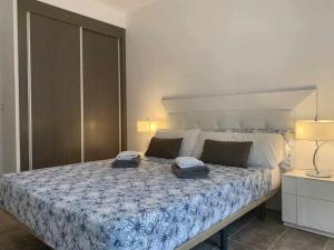 een slaapkamer met een groot bed met 2 kussens erop bij Apartamento de lujo en primera linea de playa in Benidorm