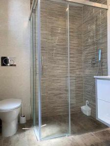 een badkamer met een douche en een toilet bij Apartamento de lujo en primera linea de playa in Benidorm